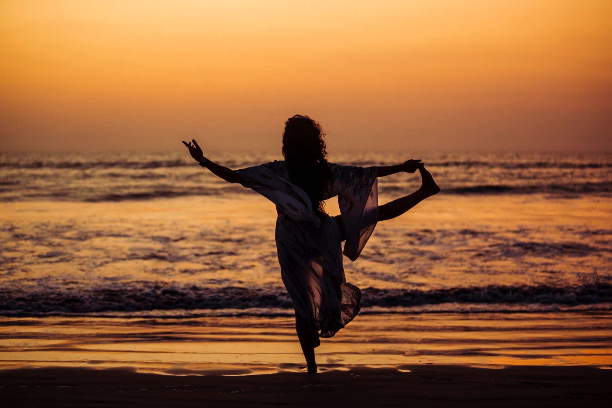 Woman practicing yoga on a beach