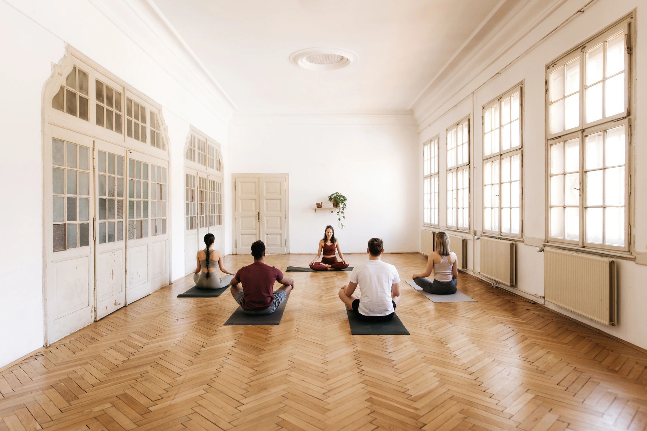Group meditating in a bright studio