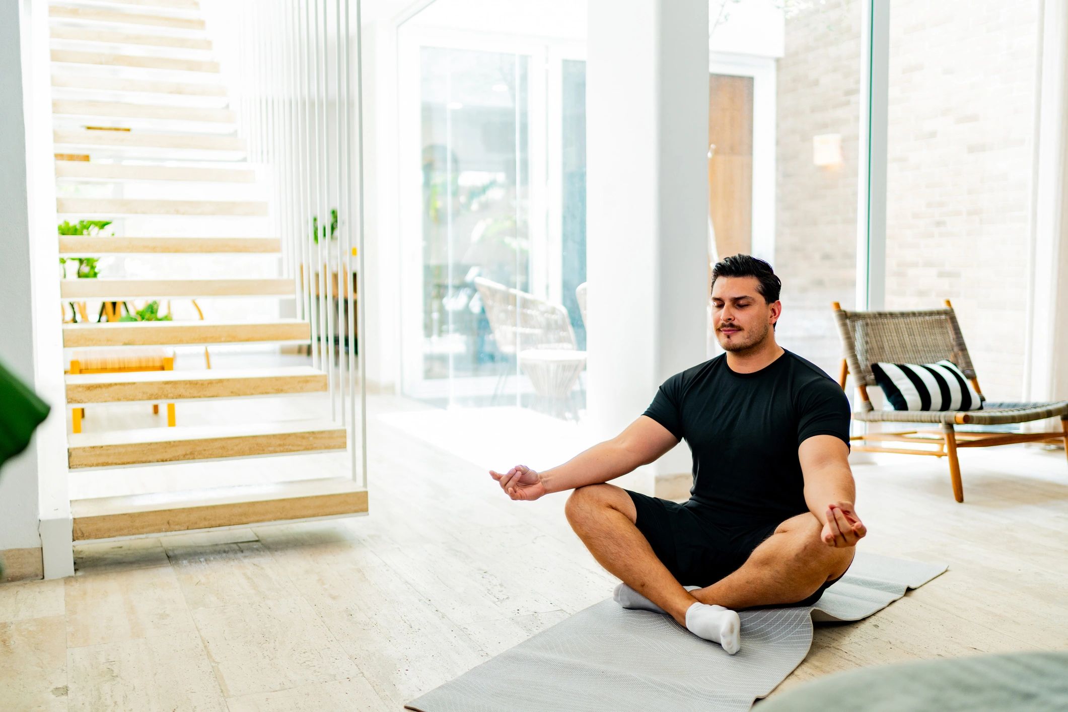A person meditating at home, representing calm, grounded leadership