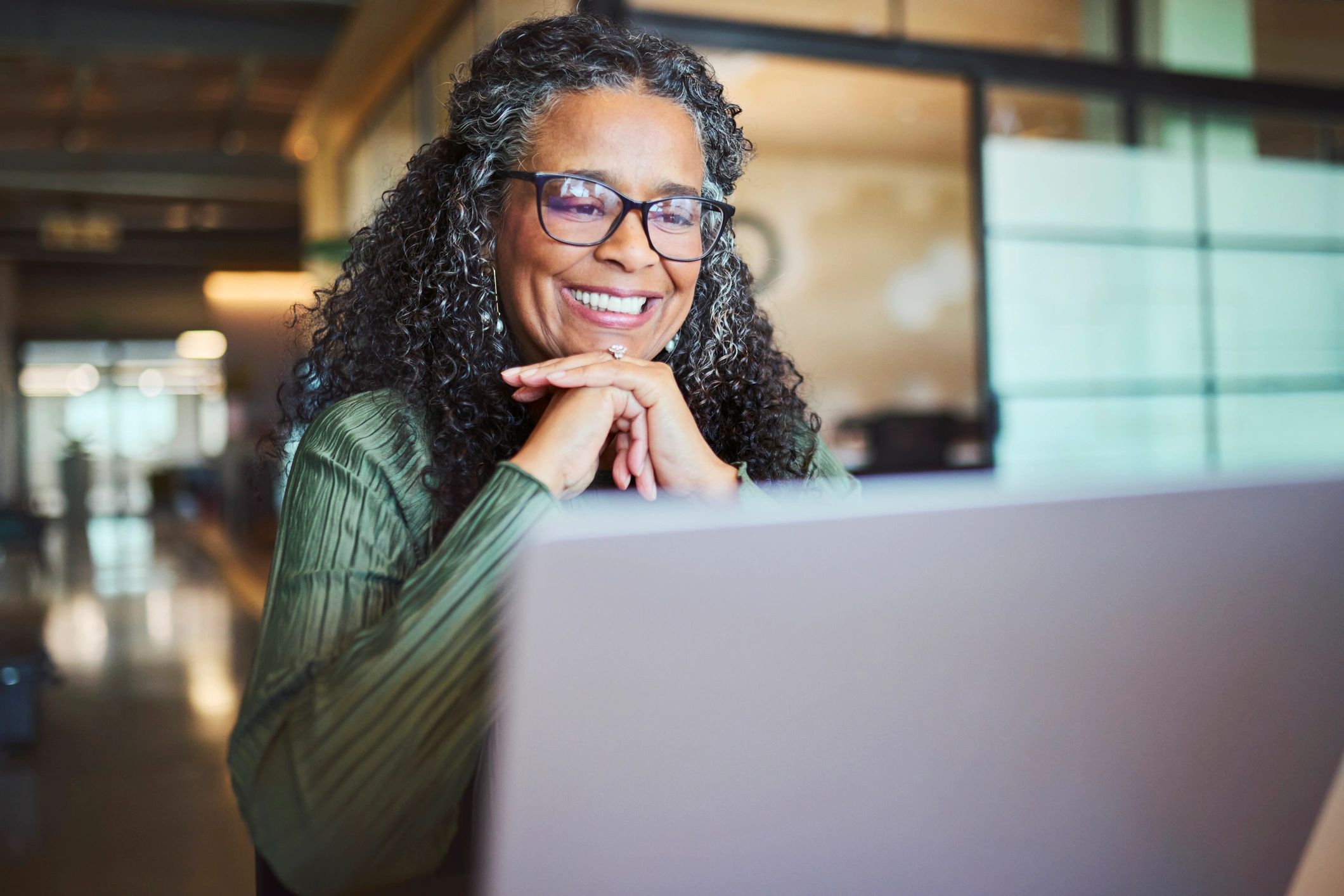 Professional smiling during a video call on a laptop